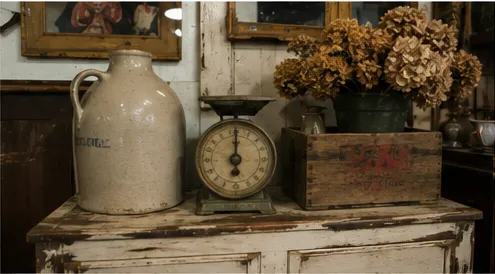 Stoneware jug and vintage kitchen scale on a chippy cabinet